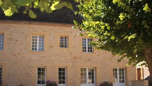 A stone building with multiple windows and doors, surrounded by gravel and potted plants. - Riverside House with pool, 4 bedrooms, 3 bathrooms, spacious with all ammenities (Mauzac-Et-Grand-Castang)