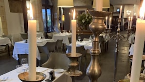 A restaurant interior with tables set for dining, candle holders, and hanging lamps. - Riverside House with pool, 4 bedrooms, 3 bathrooms, spacious with all ammenities (Mauzac-Et-Grand-Castang)