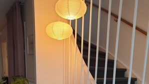 A staircase with white railings, a grey bench, and two hanging lamps. - Smålandsstenar hotell (Smalandsstenar)