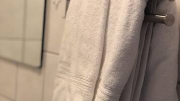 A bathroom with a towel rack holding two white towels.