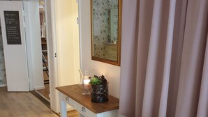 A room with a wooden desk, a white chair, a mirror, and a door leading to a hallway. - Smålandsstenar hotell (Smalandsstenar)