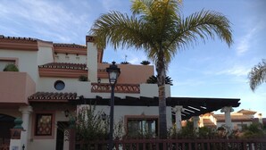 Un edificio con estilo arquitectónico tradicional, que destaca por su tejado de tejas y paredes de estuco.