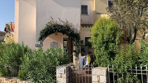 Eine Villa mit steinernen Zäunen, einem Metallzaun und einem Schild mit der Aufschrift 'Villa Gigì'.
