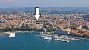 An aerial view of a coastal city with a marina filled with boats.