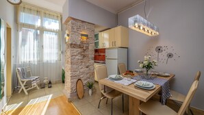 A dining area with a wooden table, chairs, and a stone accent wall.
