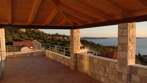 A covered terrace with stone pillars, a tiled floor, and a view of a coastal landscape with houses and the sea. - Magnificent Newly-built Villa in Mlini with Private Pool and Near Beaches (20207 Mlini)