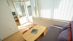 Une chambre avec un lit, une table et un téléviseur.