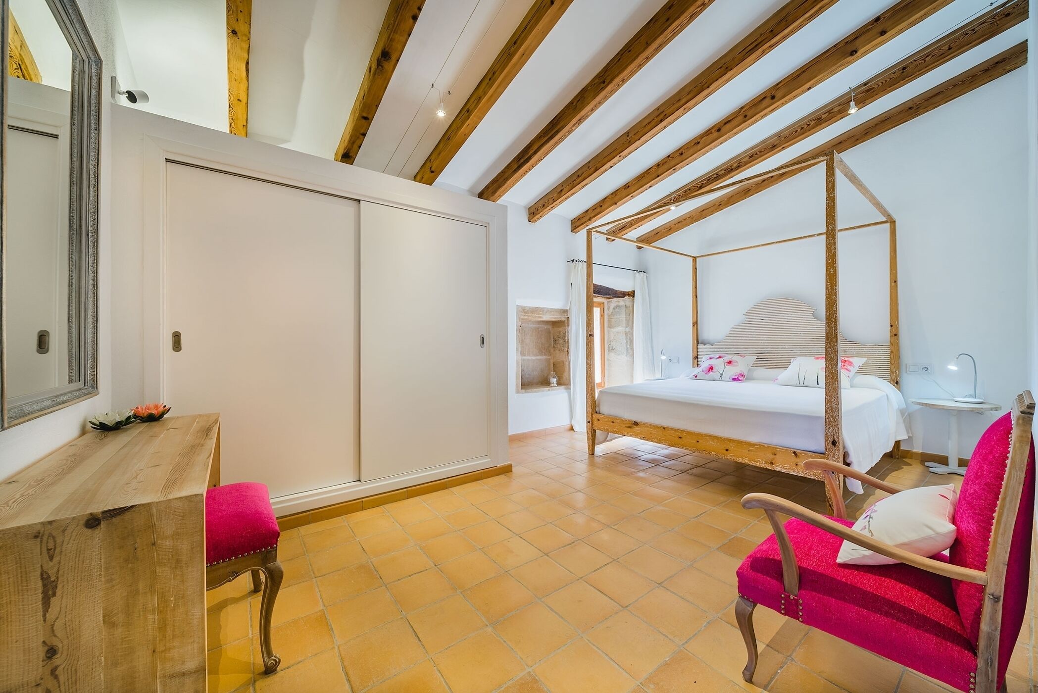 A bedroom with a wooden ceiling, a bed, a chair, and a desk.