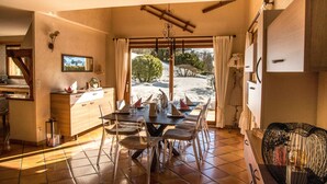 Un comedor con una mesa dispuesta para seis personas, un aparador de madera y vistas a un paisaje nevado a través de amplios ventanales.