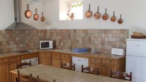 A kitchen with wooden cabinets, a tiled backsplash, a stove, a microwave, and a toaster. - Country holiday home  independant and calm (Ouzouer-Sur-Trézée)