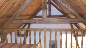 A room with a sloped wooden ceiling, a wooden railing, and a plaid floor mat. - Country holiday home  independant and calm (Ouzouer-Sur-Trézée)