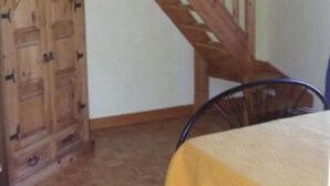 A room with a wooden staircase, a wooden cabinet, and a table with a yellow tablecloth. - Country holiday home  independant and calm (Ouzouer-Sur-Trézée)