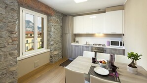 A modern kitchen with white cabinets, a microwave, and a dining area with a table set for two.