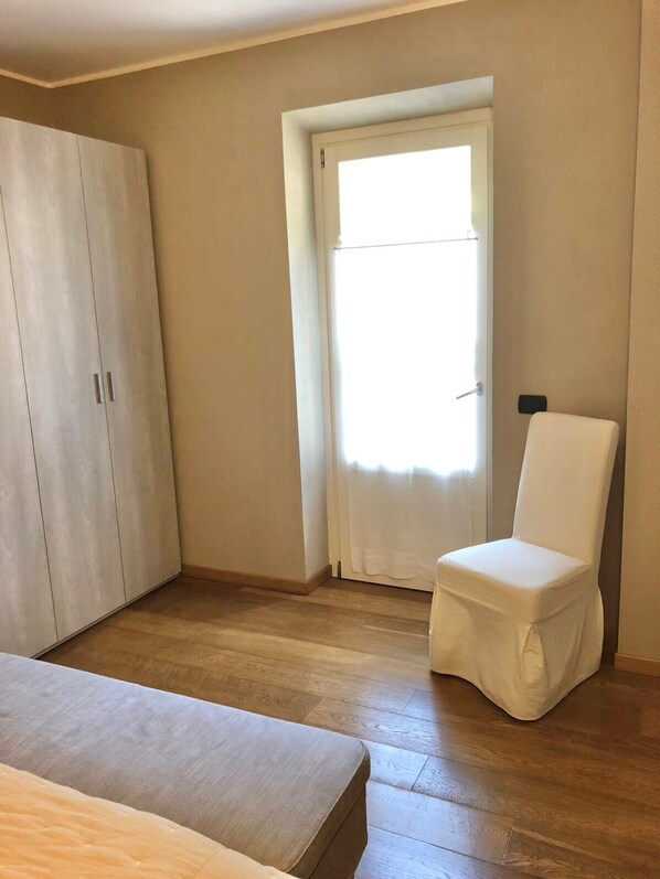 Una habitación con armario, silla y cama.