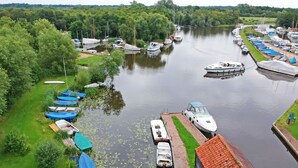 Ein Yachthafen mit vertäuten Booten am Ufer, umgeben von üppiger Vegetation.
