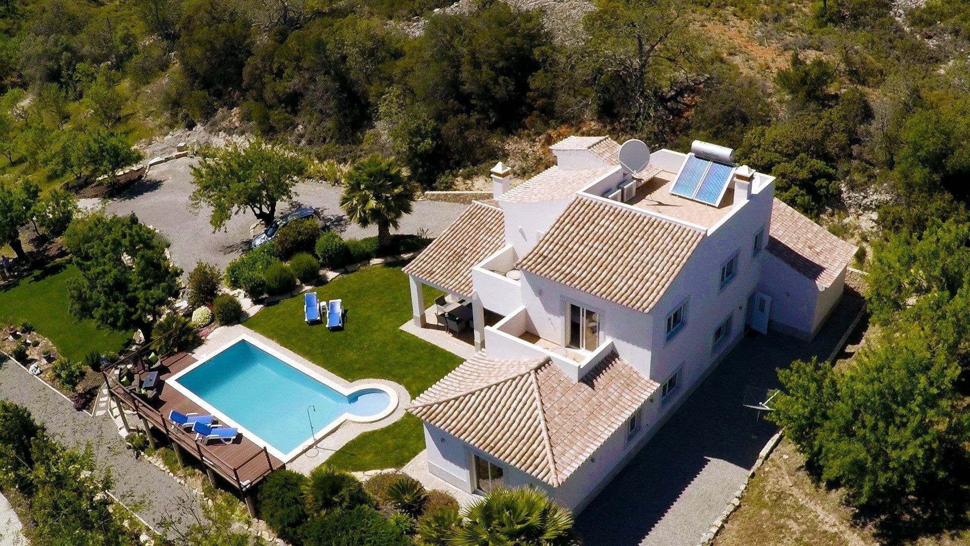 A modern villa with a swimming pool, solar panels, and a well-maintained garden.