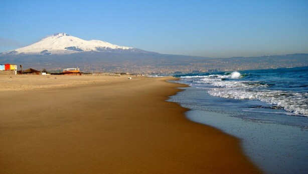 Una playa con una montaña al fondo.