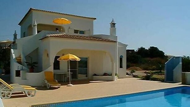 A two-story building with a swimming pool, outdoor seating, and a clear sky. - Holiday apartment ideal for a couple with private Swimming pool (Carvoeiro)
