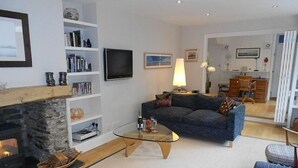 TV connectée, cheminée, livres, chaîne hi-fi