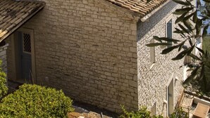 Un bâtiment en pierre avec un toit recouvert de tuiles, une petite fenêtre et une porte.