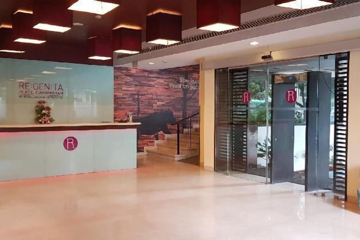 A reception area with a glass desk, a reception desk, and a staircase leading to an upper level.
