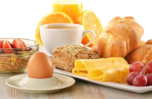 A breakfast setting with bread, cheese, grapes, a croissant, a muffin, a cup of coffee, and orange slices. - Landhaus Schöpf & Haus Alpina (Laengenfeld)