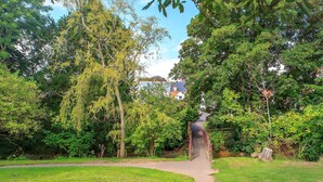 A pathway leading to a house surrounded by lush greenery. - House, Attractive Views Of The Byes, Family and Pet Friendly (Sidmouth)