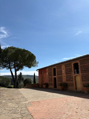 A building with a brick facade, large windows, and a door. - House with character (San Casciano in Val di Pesa)