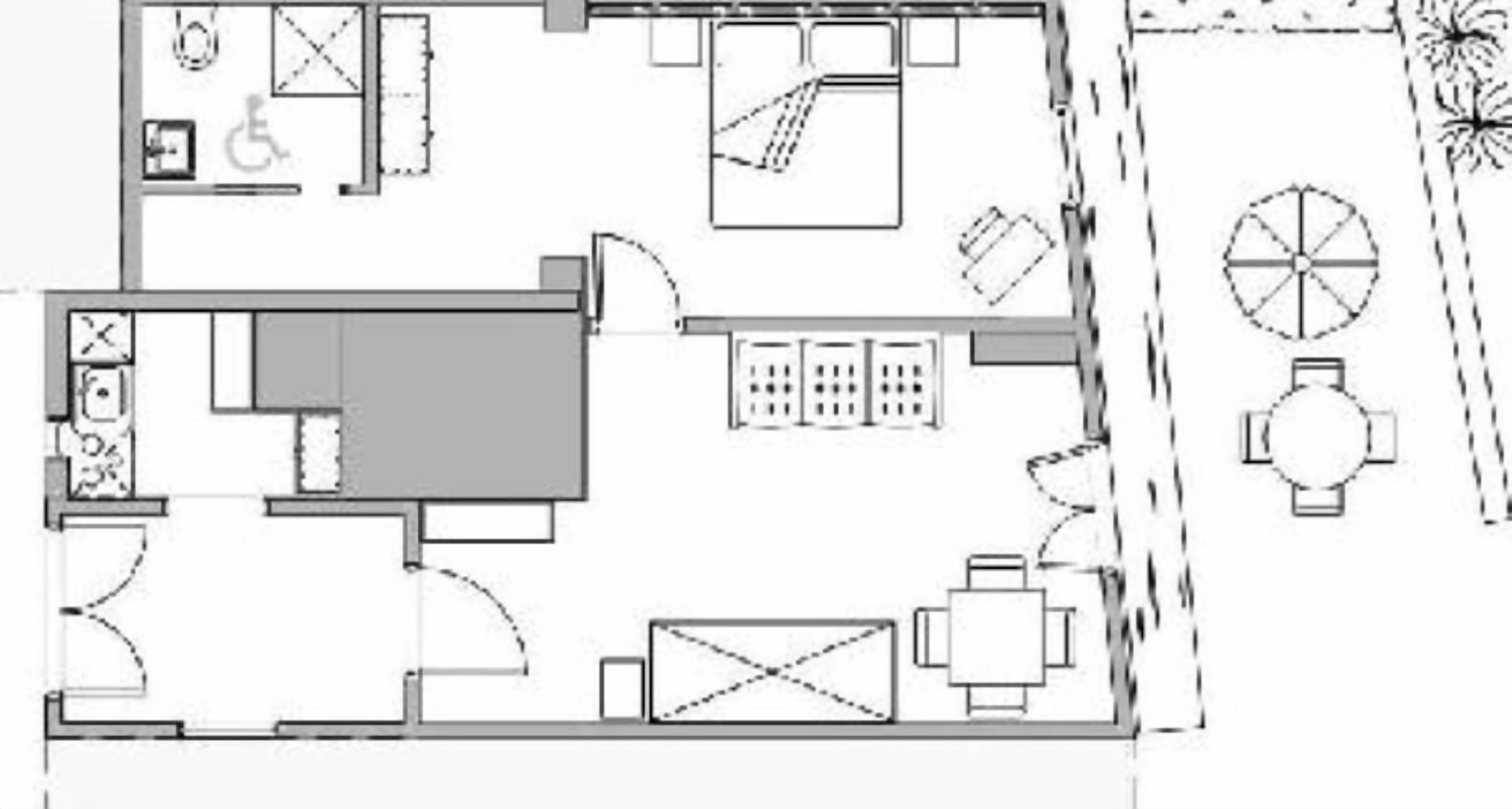 A floor plan of a hotel room with a bed, a desk, a chair, a small table, a sofa, a bathroom, and a balcony with a circular window.