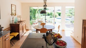 A modern kitchen with a dining area, a large window, and a view of the outdoors.
