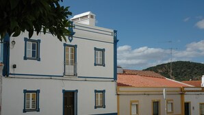 Un edificio de dos pisos con un balcón, una puerta y una ventana.