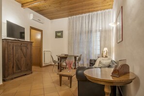 A living room with a TV, wooden cabinet, dining table, and a sofa. - GuestHost - Approximately 80 m2 apartment located on the third floor of a characteristic period building with lift (not suitable for the disabled).Our accommodation can comfortably accommodate up to 6 people.It is the ideal solution for those who travel  (Roma)