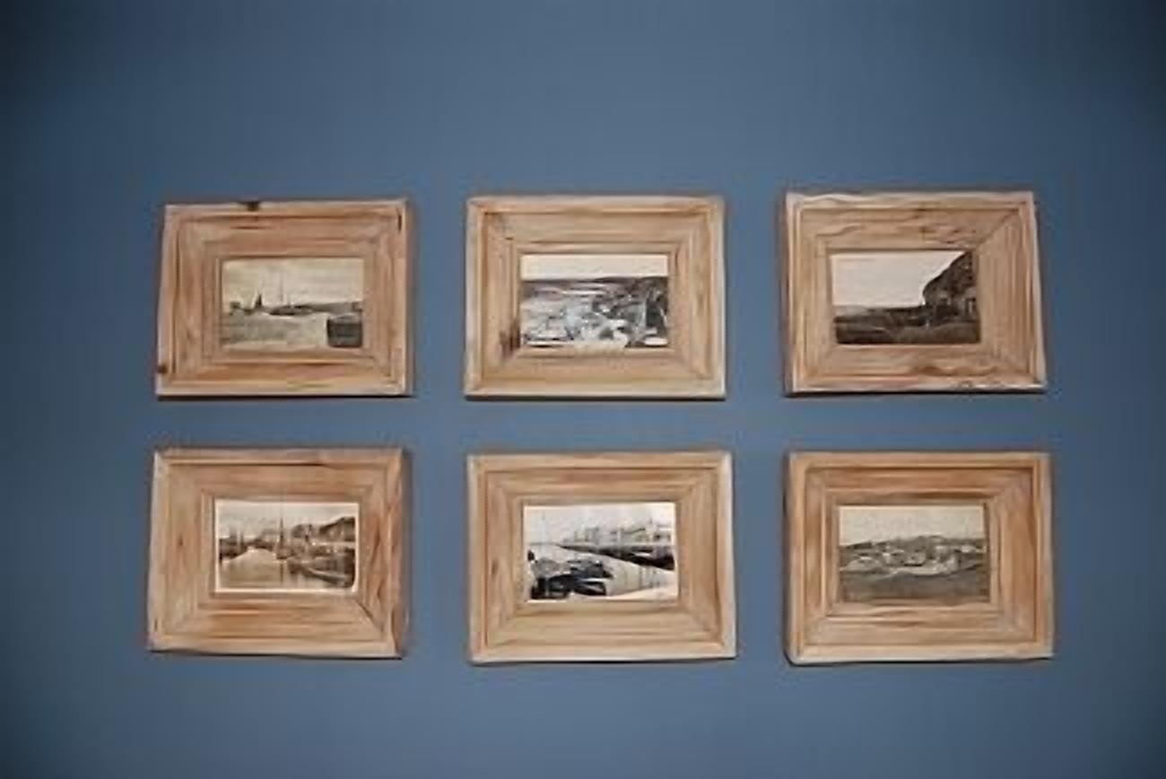 Six framed photographs arranged in two rows of three on a blue wall.