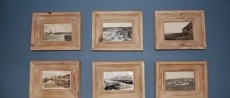 Six framed photographs arranged in two rows of three on a blue wall.