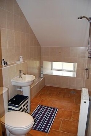 Une petite salle de bain moderne, équipée de toilettes, d’un lavabo et d’une douche.