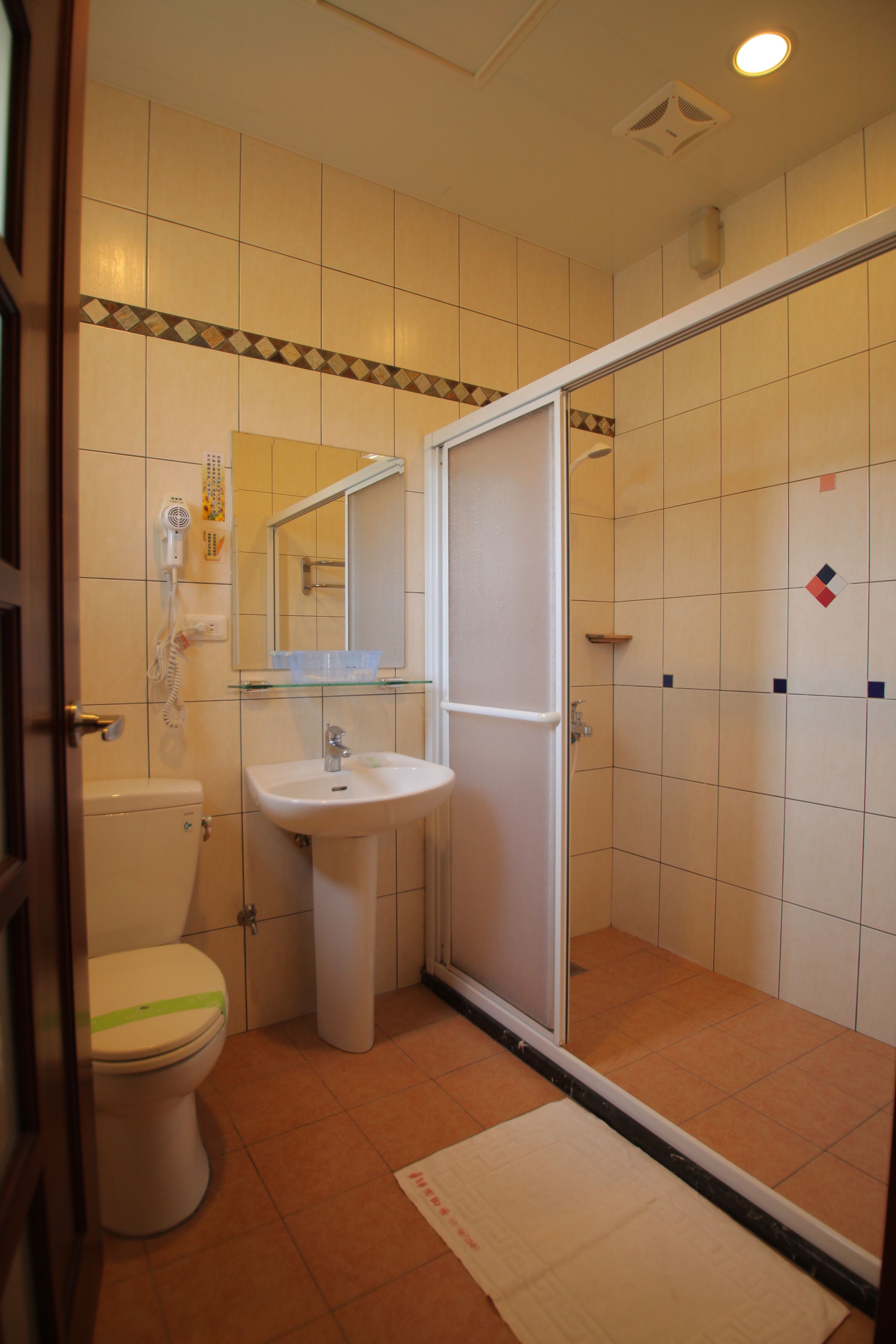 A bathroom with a toilet, sink, and shower.