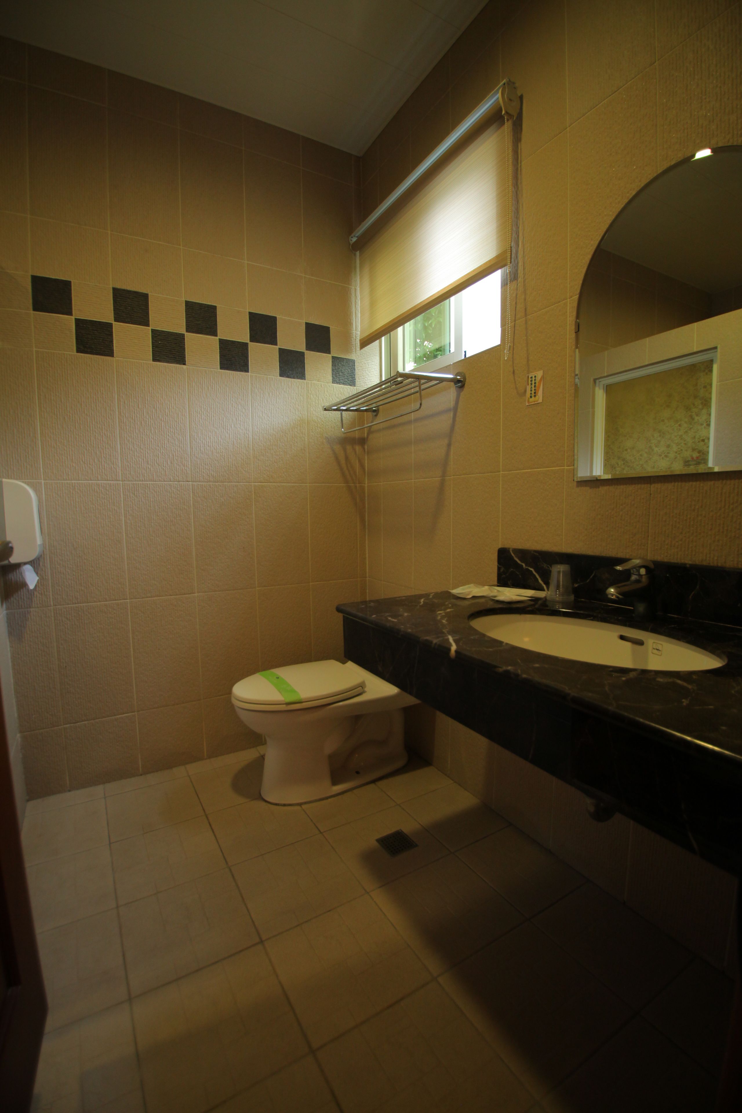 A small bathroom with a toilet, sink, and mirror.