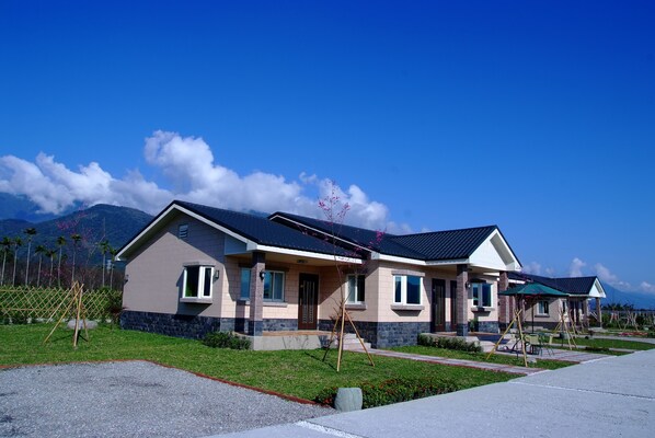 A two-story house with a sloped roof, solar panels, and a well-maintained lawn.
