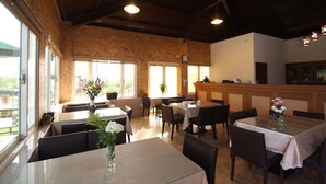 A restaurant with wooden walls, large windows, and tables with chairs. - Countryside B&B (Ruisui)