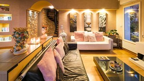 A modern living room with a sofa, a coffee table, a piano, and a bookshelf. - Pool villa with sea view near Taormina, Sicily (Taormina)
