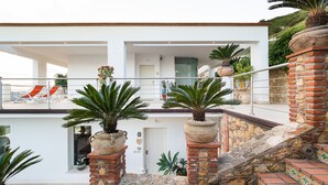 A modern two-story building with a balcony, stone steps, and potted plants. - Pool villa with sea view near Taormina, Sicily (Taormina)