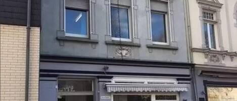 Um edifício com fachada comercial exibindo uma placa com a inscrição 'ALSO'.