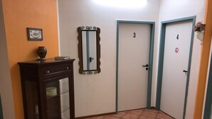 Un pasillo con dos puertas, número 3 y 4, y un armario con espejo.