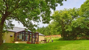A house with a conservatory, a lawn, and a garden. - Barley Cottage (Bideford)