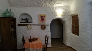 A rustic room with a wooden table, a sewing machine, and a painting on the wall.