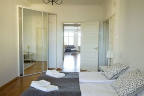 A bedroom with a bed, a bedside table, a mirror, and a view into another room. - 2ndhomes Stunning Top Floor Residence with 2BR & Sauna (Helsinki)