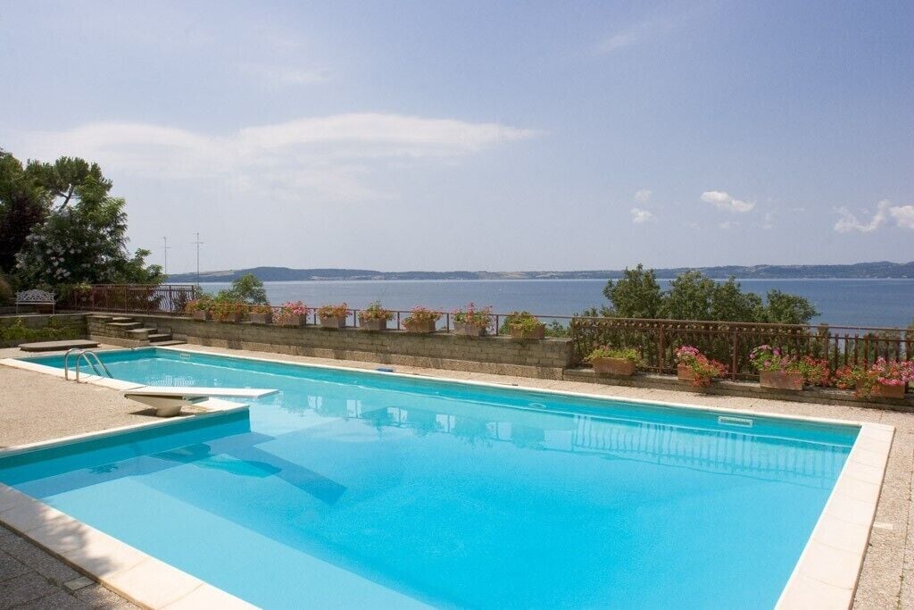 Ein rechteckiger Pool mit freiem Blick auf das Meer im Hintergrund.