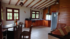 A cozy kitchen with wooden cabinets, a dining table, and a sofa.