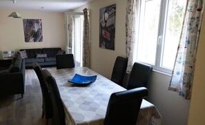 A dining area with a table, chairs, a sofa, and a window with curtains. - Detached villa in Les Mathes with private heated pool - Villa Cachée (Sleeps 10) (Les Mathes)
