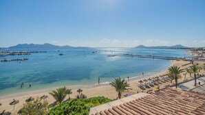 A coastal view with a beach, clear blue water, boats, and a pier. - Apartment Colorado 3B By SunVillas Mallorca (Port de Pollensa)